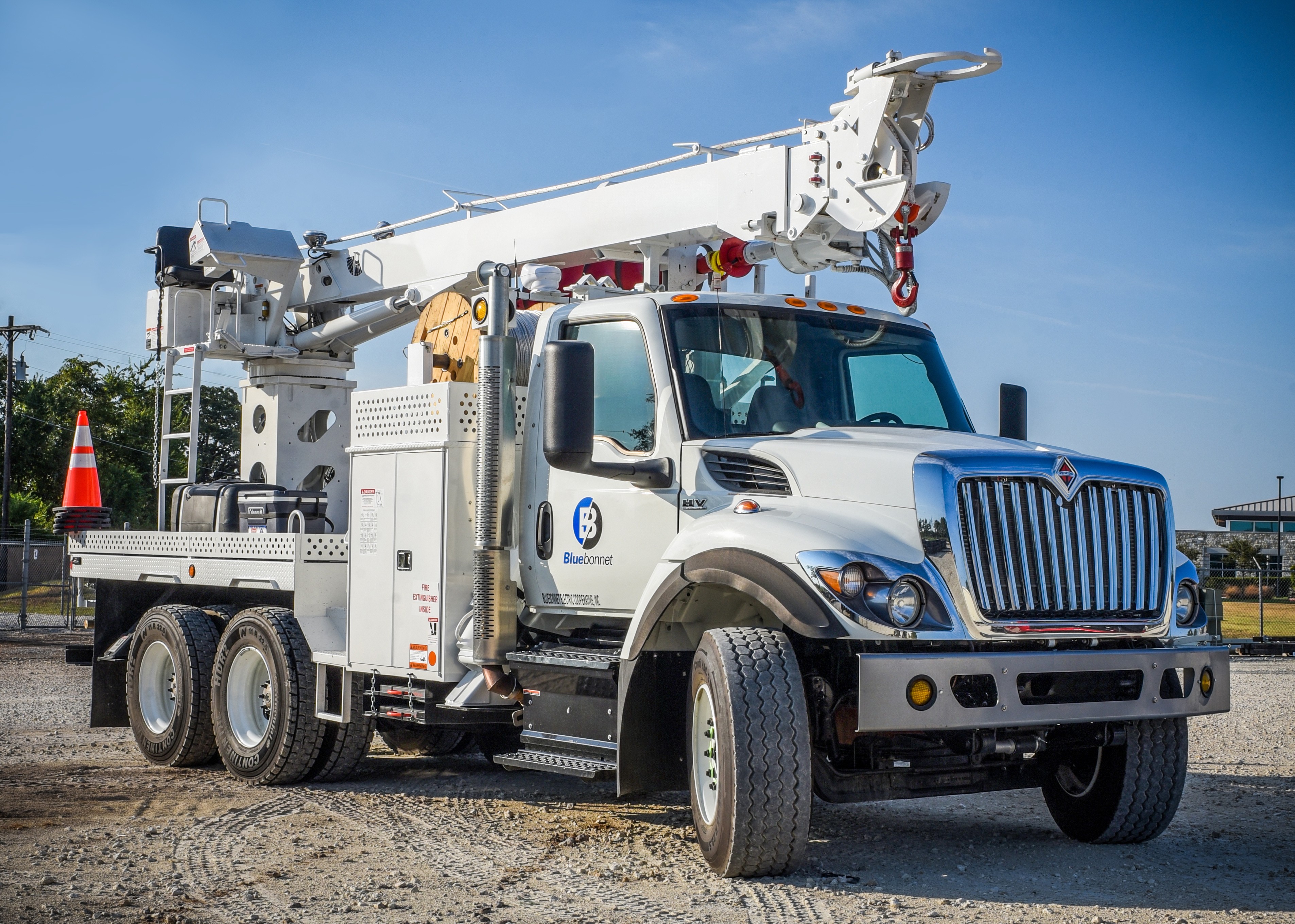 A digger truck in the Bastrop Service Center yard displays the Bluebonnet logo.