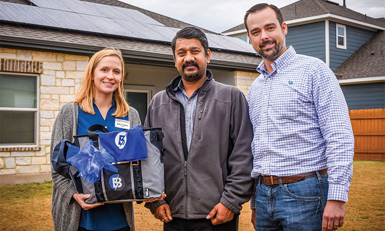 Brittany Hardy, Bluebonnet Electric Cooperative member service representative (left), Bluebonnet member Pandiyan Kaliyamoorthy of Austin (center), and Wesley Brinkmeyer, Bluebonnet's manager of energy services. (Sarah Beal photo)