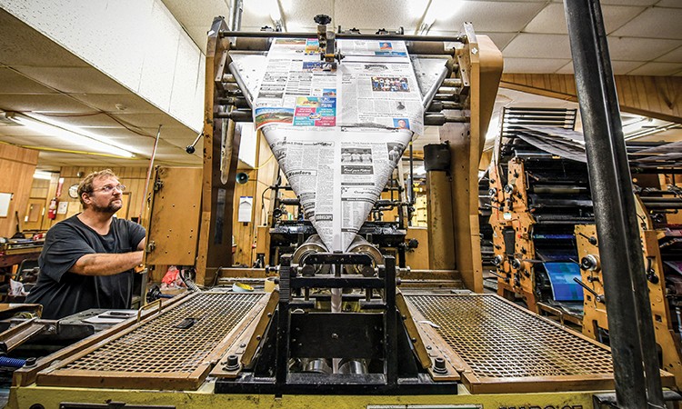 Printing supervisor Clifton Green, who has been at the Brenham Banner Press for more than 30 year, checks the calibration of the printing press.
